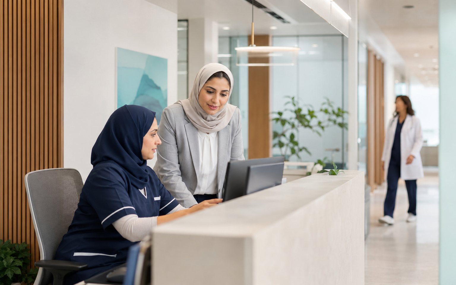 Clinic operations colleagues collaborating at a contemporary GCC reception area
